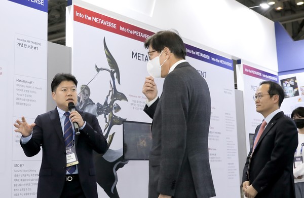 박형준 부산시장(가운데)이 ‘BWB2022’에 참가한 미디움-BNK부산은행 공동전시관에서 조영준 미디움 부사장(왼쪽)과 BNK부산은행 김상환 상무(오른쪽)의 전시관 설명을 듣고 있다.