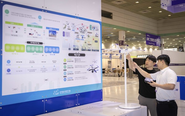 서울 코엑스에서 19일까지 열리는 ‘무인이동체 산업엑스포 2024’에서 SKT와 원자력연구소 관계자가 불법 드론 대응 체계에 대해 대화하는 모습.