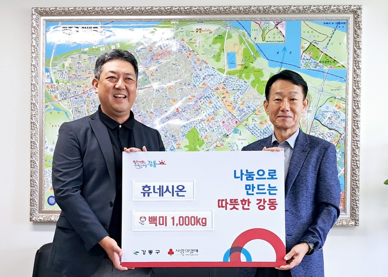 4일 휴네시온 최진석 전무(왼쪽)가 강동구청에 방문해 쌀 1,000kg를 전달한 뒤 강동구청 손완현 복지가족국장과 기념촬영을 하고 있다.
