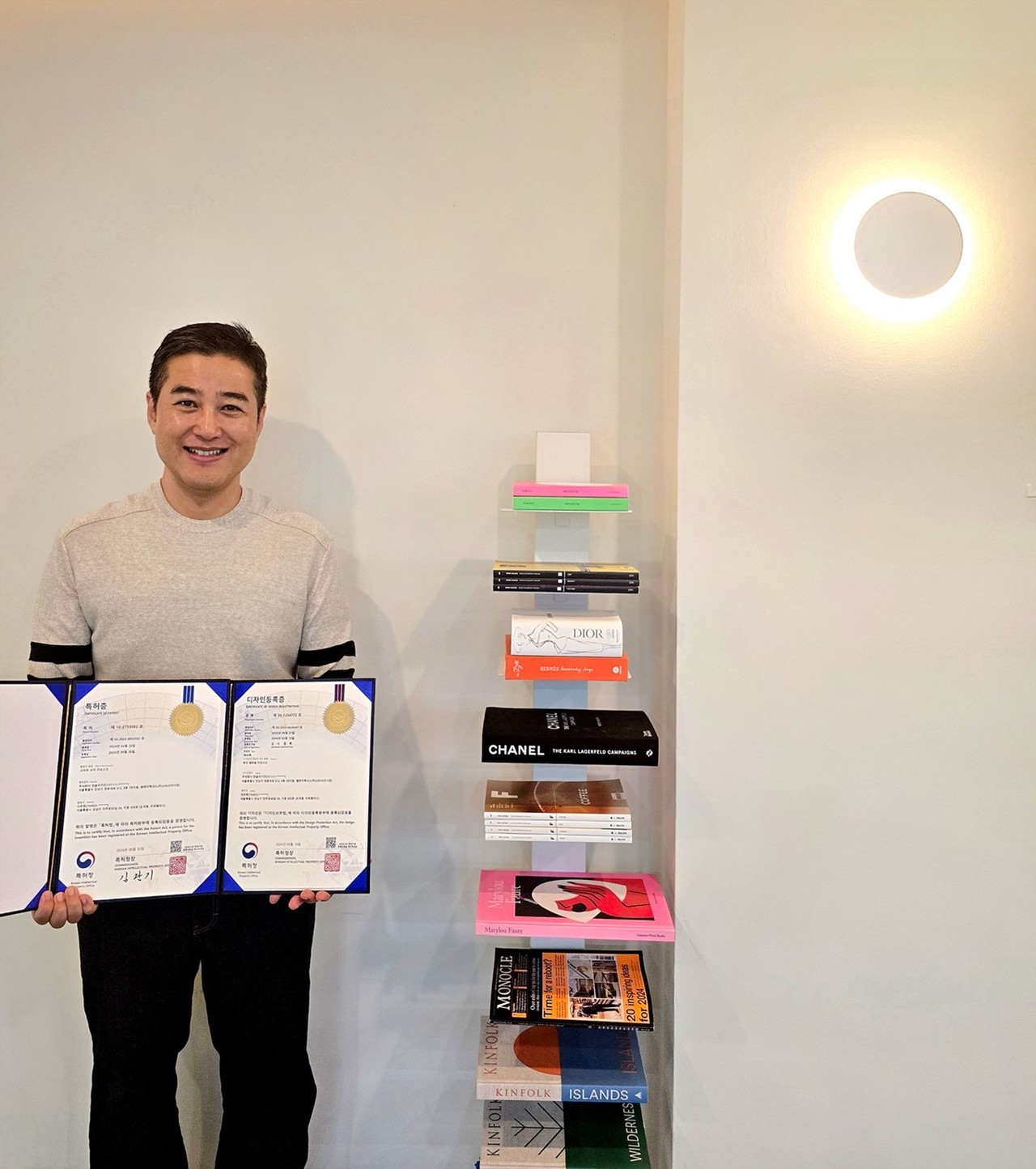 먼키 김혁균 대표가 기술 특허와 디자인 특허를 들어 보이고 있다.