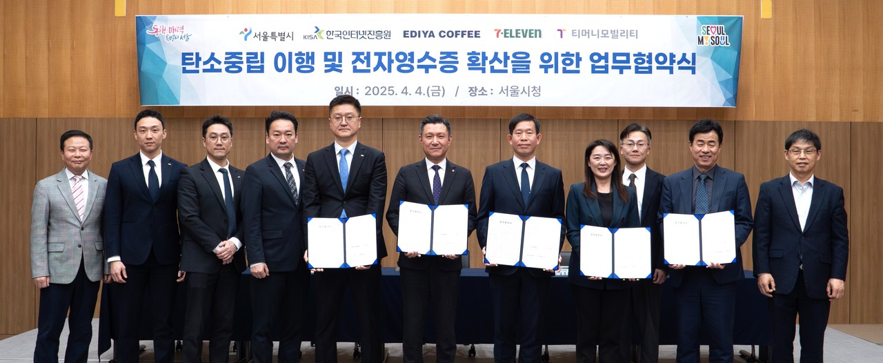 지난 4일 서울시청 서소문청사에서 열린 ‘탄소중립 이행 및 전자영수증 확산을 위한 업무협약식’에서 관계자들이 기념 촬영을 하고 있다. (왼쪽 앞줄 다섯 번째부터) 이디야 조규동 대표, 코리아세븐 김홍철 대표, 서울시 권민 기후환경본부장, KISA 김정희 디지털안전지원본부장, 티머니모빌리티 조동욱 대표 (사진=KISA)