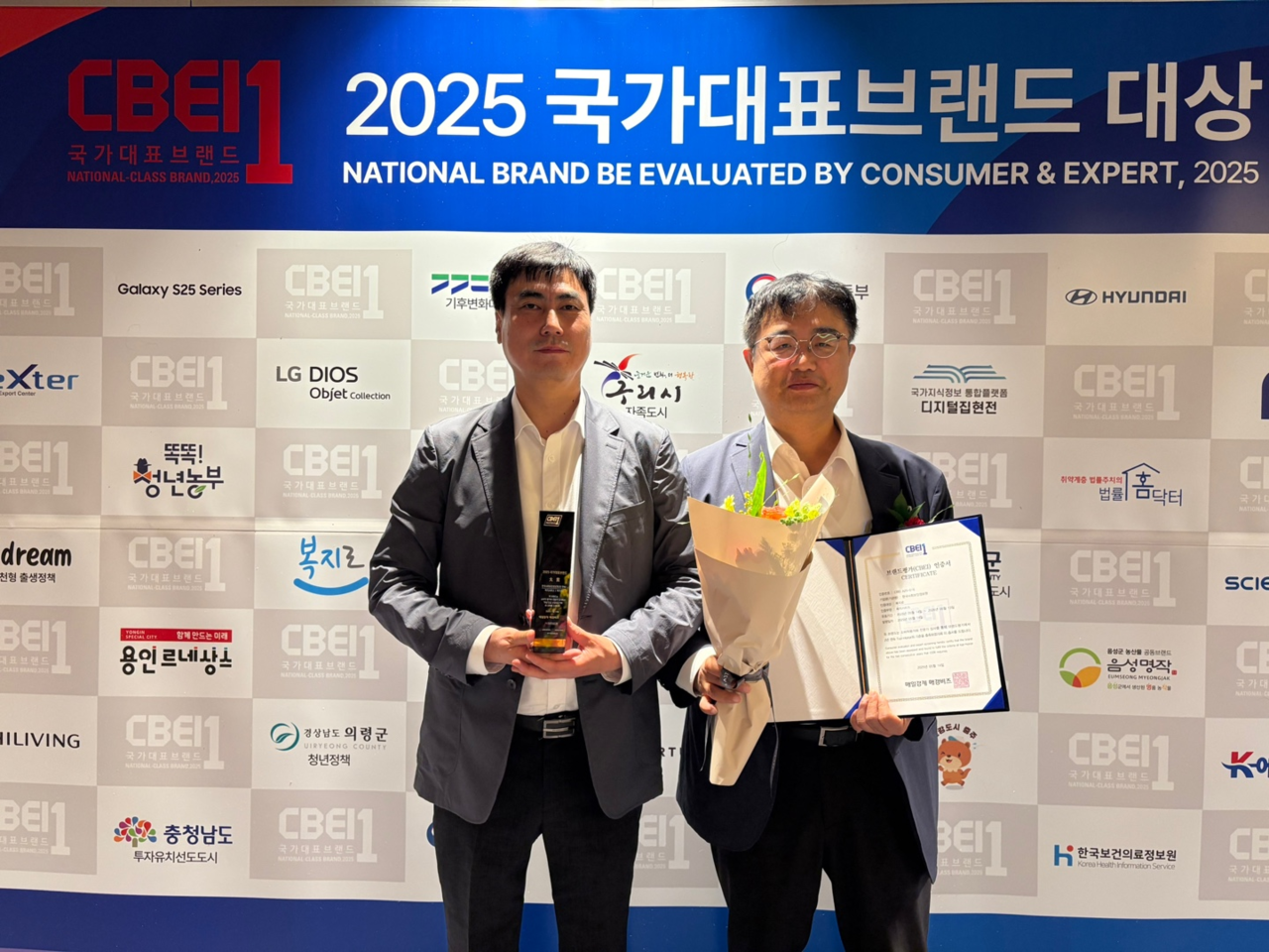 한국사회보장정보원 윤상경 본부장(오른쪽 첫 번째)과 이승조 부장이 지난 14일 ‘국가대표브랜드 2025’에서 대상 수상 후 기념촬영을 하고 있다.