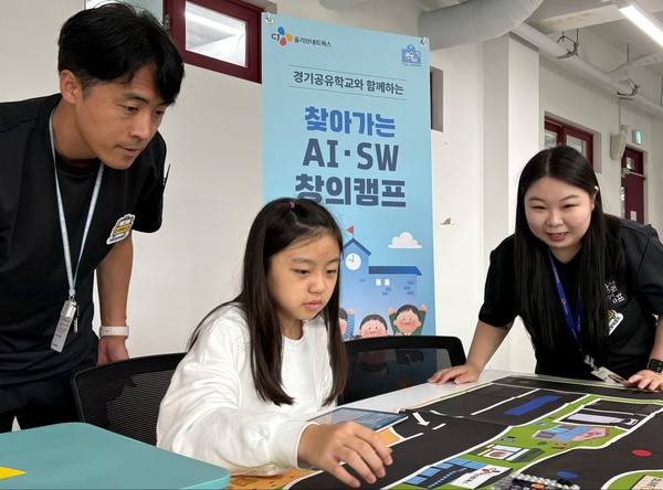 참가학생이 CJ올리브네트웍스 임직원 강사들과 함께 자신이 코딩한 자율주행차의 이동경로를 확인하고 있다.